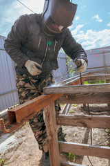 Welder welds metal at the construction site