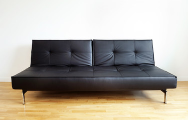 Black leather sofa on a white background