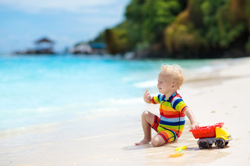 Kids play on tropical beach. Sand and water toy.