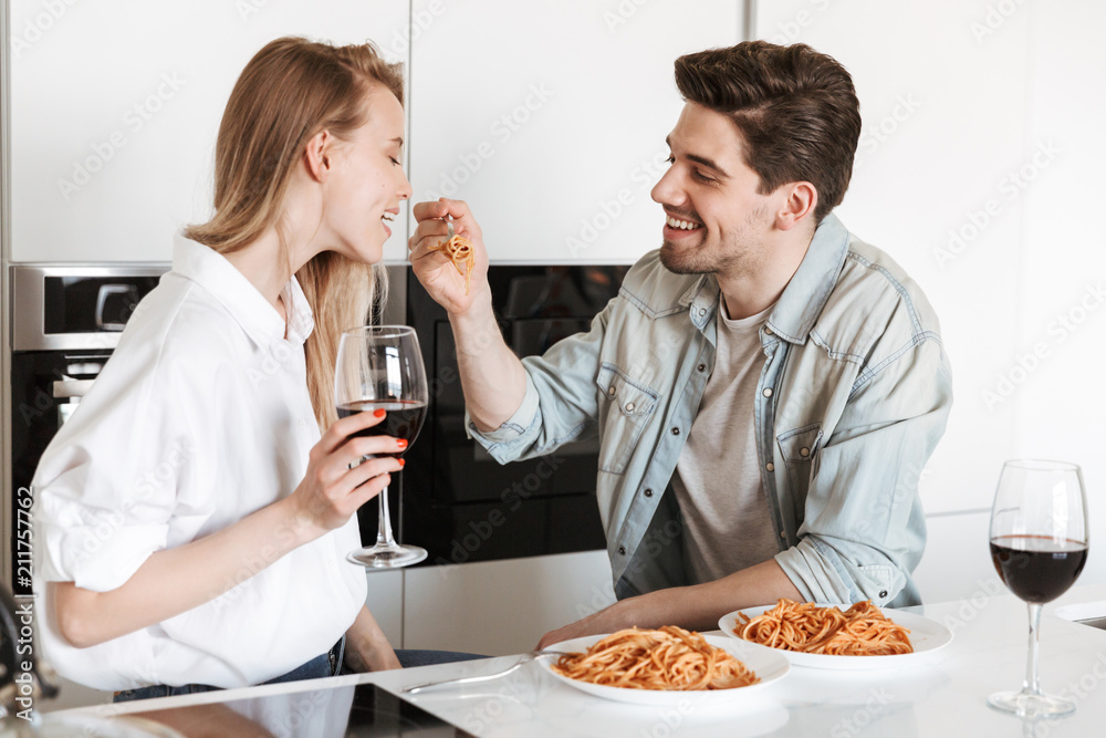 Poster Loving couple in kitchen have a dinner