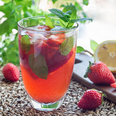 Glass of refreshing iced tea with strawberries and mint, square format
