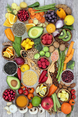 Health food concept with fruit, vegetables, herbs, spice, nuts, seeds, grain and pulses. Super foods high in antioxidants, anthocyanins, smart carbohydrates, fibre, vitamins and minerals.