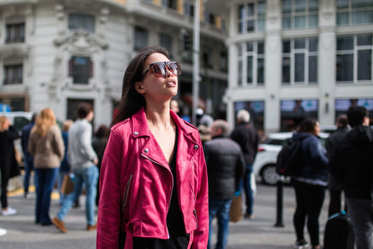 Stylish woman in pink jacket on street