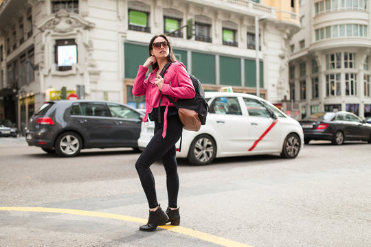 Stylish woman in pink jacket on street