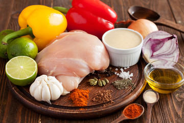 Raw chicken breast, bell peppers, limes, onion, garlic, olive oil, spices. Ingredients for chicken skewers with vegetables preparation