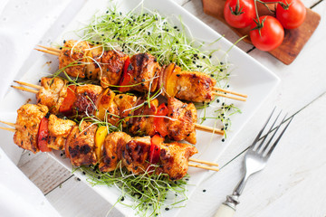 Mediterranean grilled chicken skewers served with microgreen and cherry tomatoes