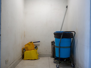 Blue and Yellow plastic buckets and janitor tools.