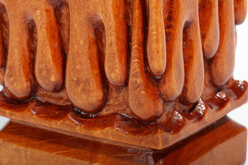 Base of the old brown wooden candlestick with carved droplets in form of melted wax. Isolated on a white