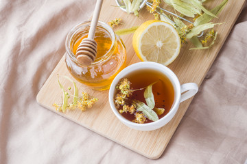 Tea with Linden, honey and Lemon. The tray on the bed, the Concept of the treatment of colds