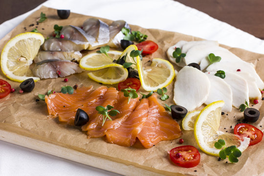 Different types of fish herring, salmon on wooden Board