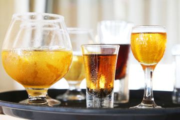 Glasses of all kind of cold alcohol beverages, on tray, closeup