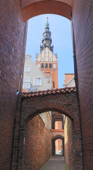 Obraz premium Church Path ( Ścieżka Kościelna) in Elblag. View of tower of St. Nicholas Church 