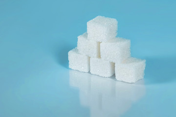 Sugar cubes on light blue background