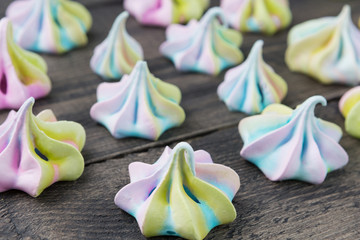 many multi-colored meringues on brown wooden boards, close-up shot, selective focusing