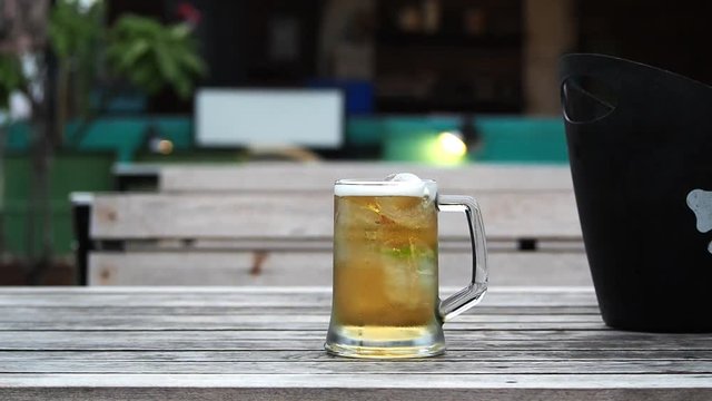 Beer in the glass on wooden table.