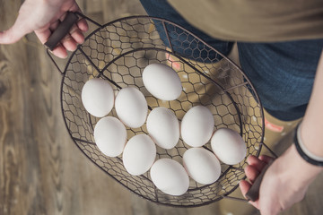 White chicken eggs in wire mesh basket