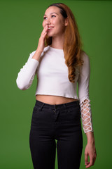 Young beautiful Asian woman against green background
