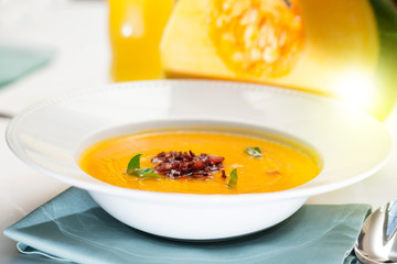 beautiful flow, pumpkin soup with fried bacon, close-up, restaurant