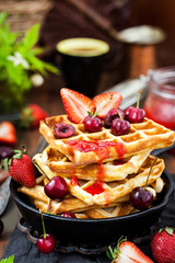 Belgian waffles with fresh berries and jam for breakfast