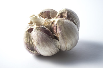 Fresh garlic on white background. Garlic cloves. Peeled garlic bulbs on jute.
