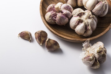 Fresh garlic on white background. Garlic cloves. Peeled garlic bulbs on jute.