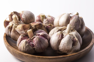 Fresh garlic on white background. Garlic cloves. Peeled garlic bulbs on jute.