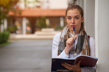 Portrait of a cute female sociologist engaged with a survey with pen and notebook in hand on a...