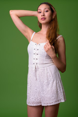 Young beautiful Asian woman against green background