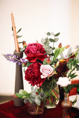 Bouquets of red and white roses and lavander decorate tables prepared for wedding dinner