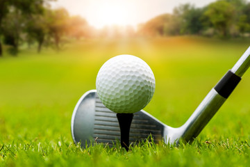 Fototapeta na wymiar Golf club and golf ball on tee in grass in sunrise. 