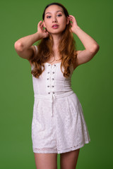 Young beautiful Asian woman against green background