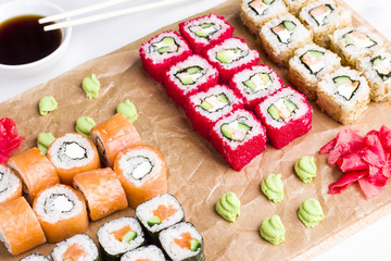 Set of different types of Japanese sushi rolls on wooden Board