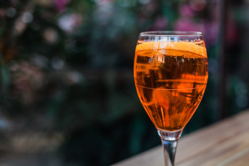 Aperol spritz cocktail in glass on wooden table on dark background in cafe