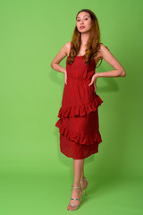 Young beautiful Asian woman against green background