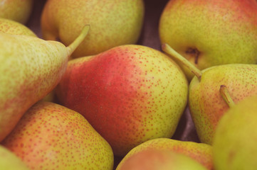 Juicy fruit background texture of yellow red ripe pears on market closeup
