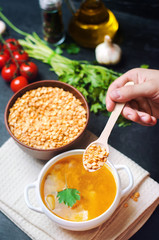 fresh liquid pea soup on pork broth. bean soup with parsley. healthy breakfast. black concrete background. selective focus.