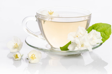 Glass cup of Tea with jasmine flowers and leaves