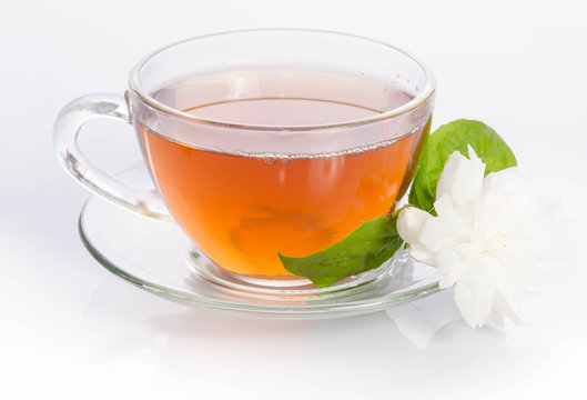 Glass cup of Tea with jasmine flowers and leaves