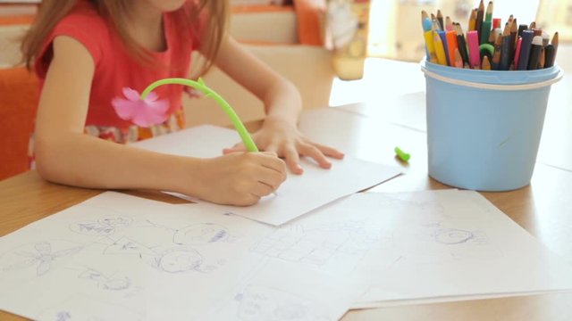 Little girl drawing pictures on paper