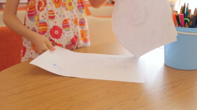 Little girl drawing pictures on paper