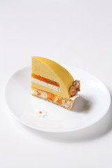 Contemporary Mango Apricot and Coconut Mousse Cake, on white background.
