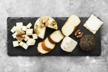 Various types of cheese on a gray background. Top view. Food background