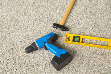 Construction concept - Hammer, drill and builders level on the floor