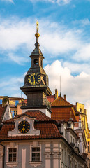 Fototapeta premium Clocks and spire with hebrew on the Jewish Town Hall in Josefov quarter of town. Tower and roof of High synagogue in Prague, Czech Republic