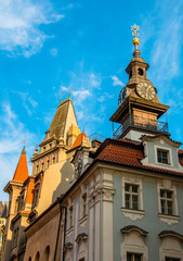 Clocks and spire with hebrew on the Jewish Town Hall in Josefov quarter of town. Tower and roof of High synagogue in Prague, Czech Republic