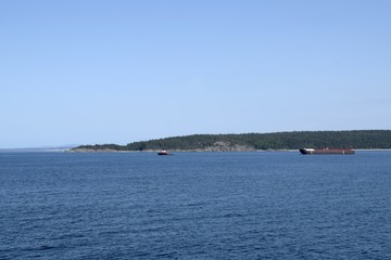 industrial ship guided by a pilot boat in the waters of the Strait of Georgia near Harwood Island,  British Columbia Canada 