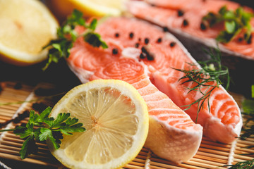 Salmon steaks with lemon and spices close up view.