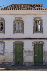 Fototapeta na wymiar Abandoned house with green doors