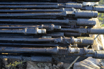 Oil Drill pipe. Rusty drill pipes were drilled in the well section. Downhole drilling rig. Laying the pipe on the deck. View of the shell of drill pipes laid in courtyard. pump rod