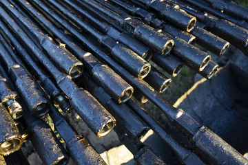 Oil Drill pipe. Rusty drill pipes were drilled in the well section. Downhole drilling rig. Laying the pipe on the deck. View of the shell of drill pipes laid in courtyard. pump rod